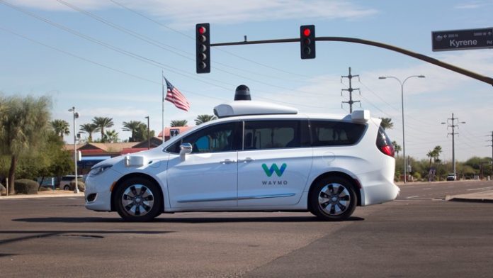 A Waymo self-driving vehicle moves through an intersection in Chandler Arizona